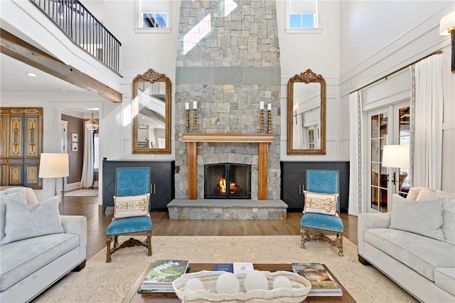 living room featuring a fireplace, hardwood / wood-style floors, and a high ceiling