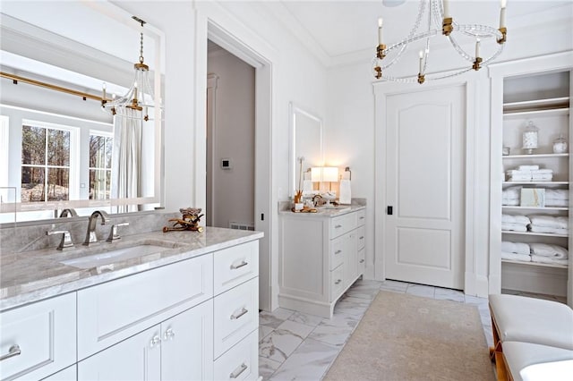 bathroom featuring ornamental molding, a chandelier, and vanity