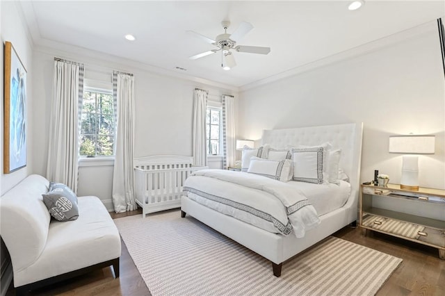 bedroom with dark wood-type flooring, ceiling fan, and ornamental molding