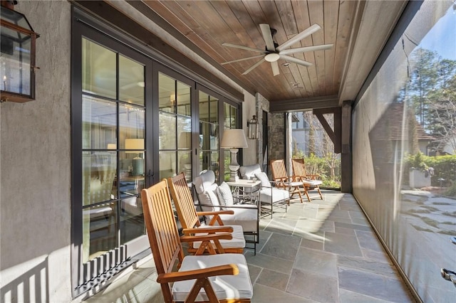 sunroom / solarium featuring wooden ceiling and ceiling fan