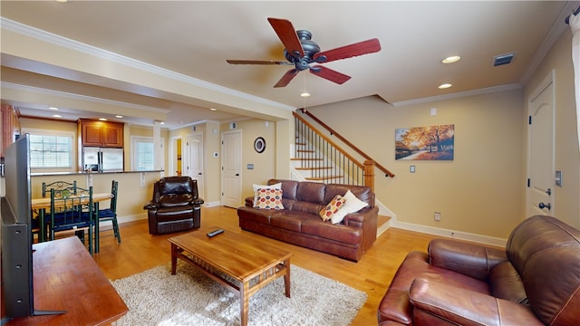 living room with crown molding, ceiling fan, and light wood-type flooring