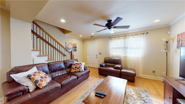 living room featuring ornamental molding, light hardwood / wood-style floors, and ceiling fan