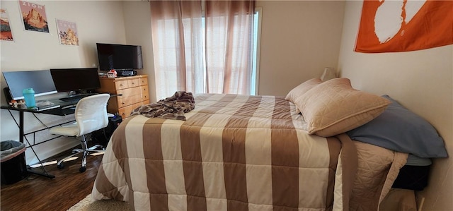 bedroom featuring multiple windows and dark wood-type flooring