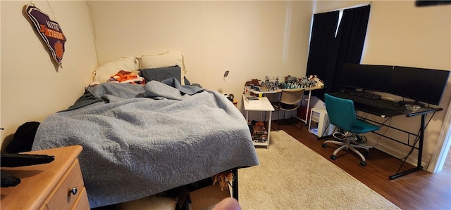 bedroom with dark hardwood / wood-style flooring