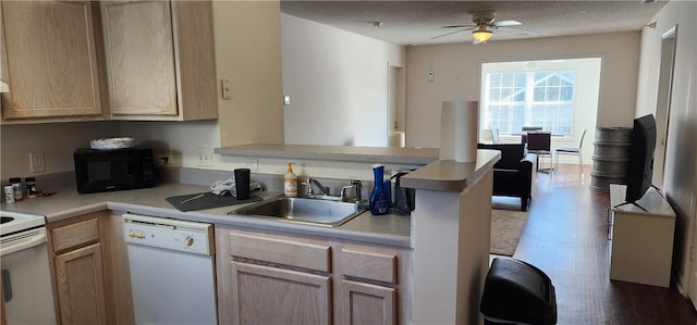 kitchen featuring white appliances, kitchen peninsula, sink, and light brown cabinets