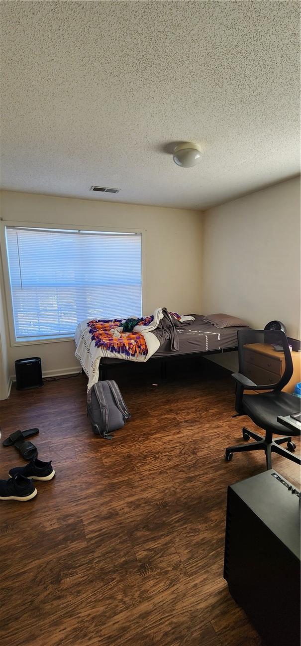 bedroom featuring dark hardwood / wood-style floors and a textured ceiling