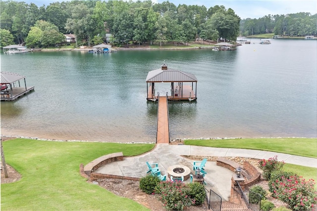 dock area with a gazebo, a water view, and a lawn