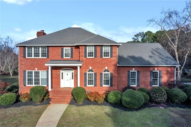 colonial-style house with a front lawn