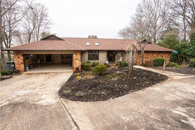 single story home featuring a carport and central air condition unit