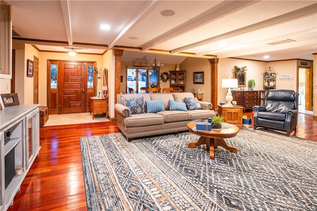 living room featuring beamed ceiling, wood-type flooring, a notable chandelier, and crown molding