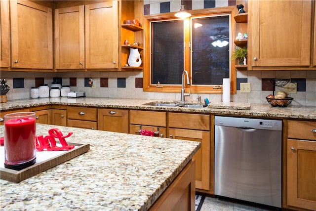 kitchen featuring tasteful backsplash, stainless steel dishwasher, light stone countertops, and sink