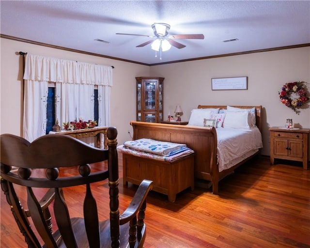 bedroom featuring ceiling fan, ornamental molding, and wood-type flooring