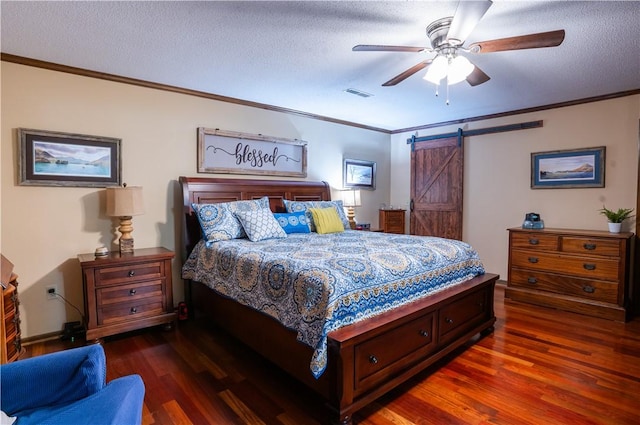 bedroom with crown molding, dark hardwood / wood-style floors, and a barn door