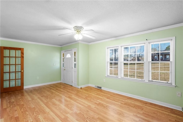 unfurnished room featuring a textured ceiling, ornamental molding, light hardwood / wood-style floors, and ceiling fan