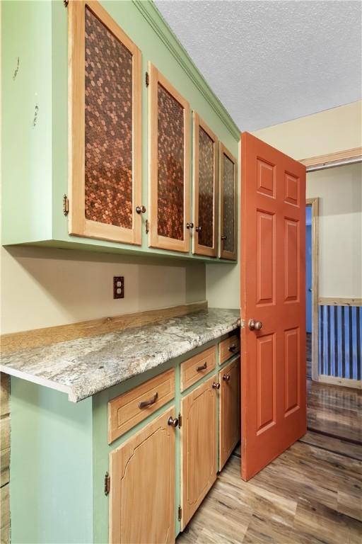 109 Pine Tree Ln, Anderson, SC 29625 - kitchen with light wood finished floors, a textured ceiling, and glass insert cabinets