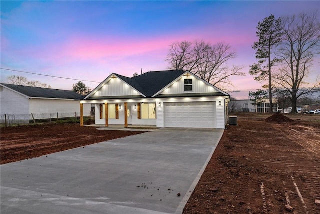 view of front of property featuring cooling unit, a garage, and a porch