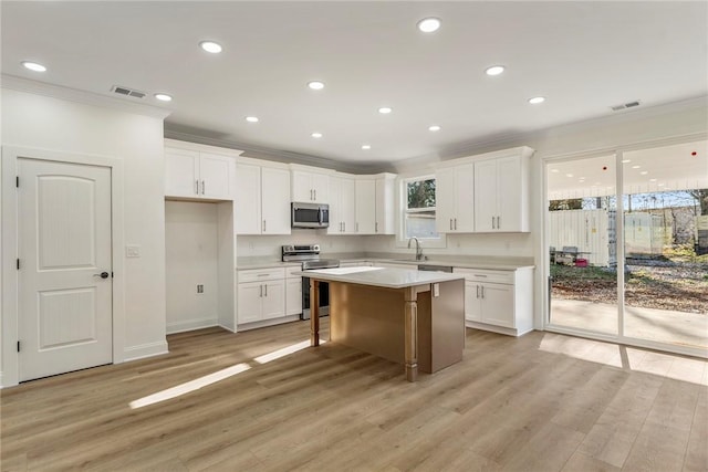 kitchen with stainless steel appliances, a center island, and white cabinets