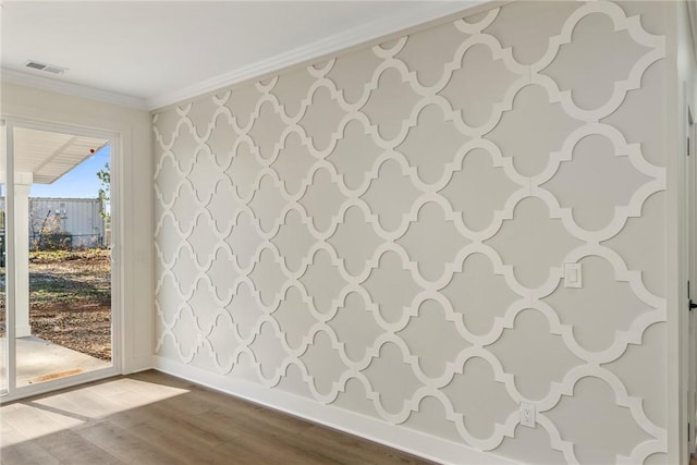 empty room featuring hardwood / wood-style flooring, ornamental molding, and a healthy amount of sunlight