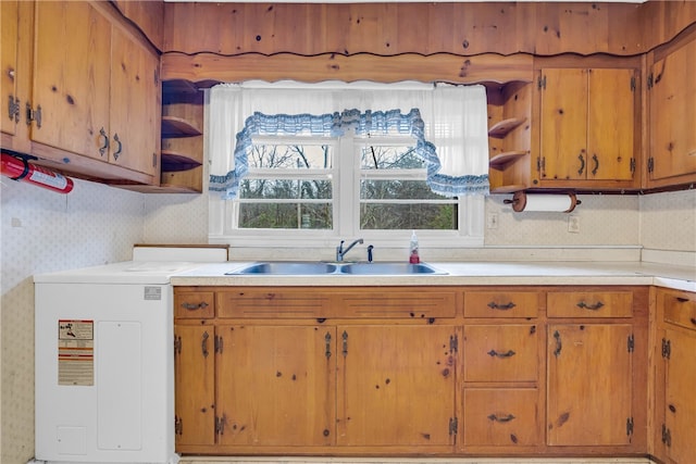 kitchen with tasteful backsplash, washer / clothes dryer, and sink