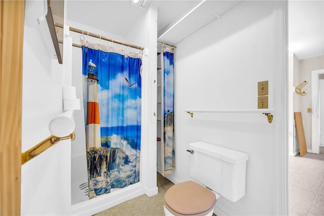 bathroom featuring curtained shower and toilet