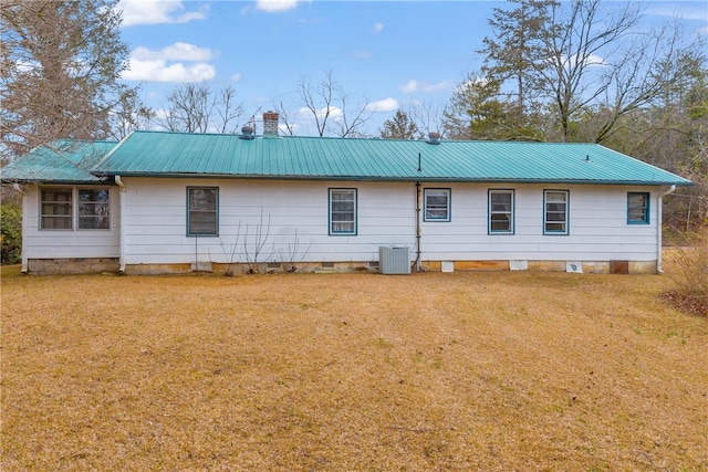 rear view of property featuring central AC and a yard