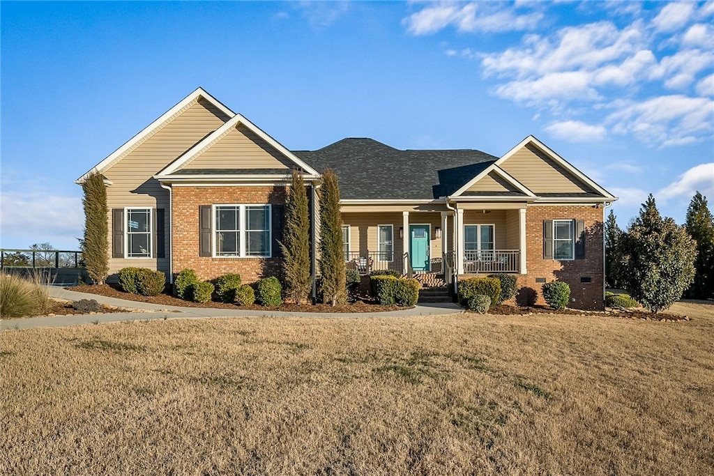 craftsman inspired home featuring a porch and a front yard