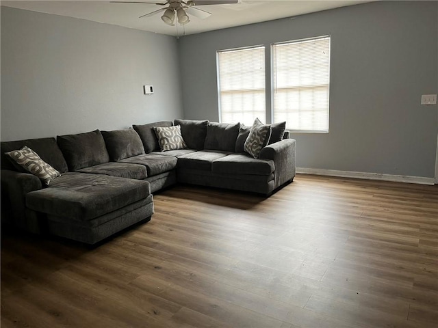 living room featuring dark wood-type flooring and ceiling fan