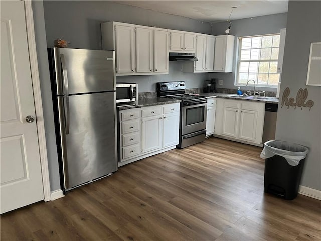 kitchen featuring stainless steel appliances, white cabinetry, sink, and dark wood-type flooring