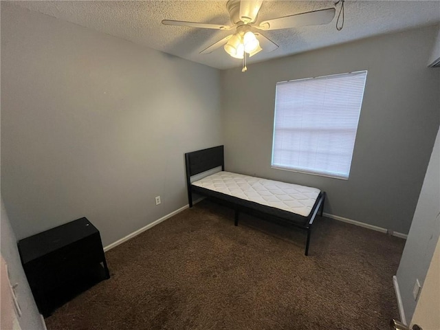 bedroom with dark carpet, a textured ceiling, and ceiling fan