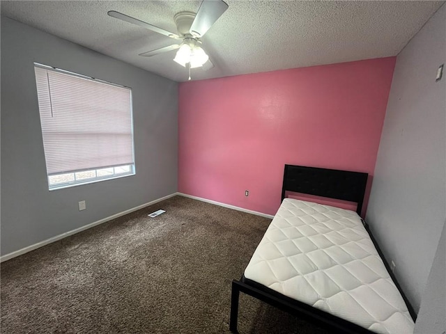 unfurnished bedroom with ceiling fan, carpet floors, and a textured ceiling