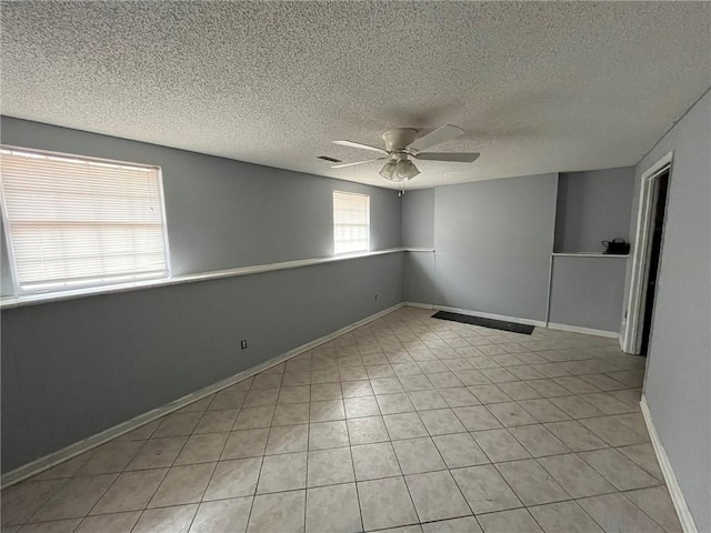 spare room featuring light tile patterned floors, a textured ceiling, and ceiling fan