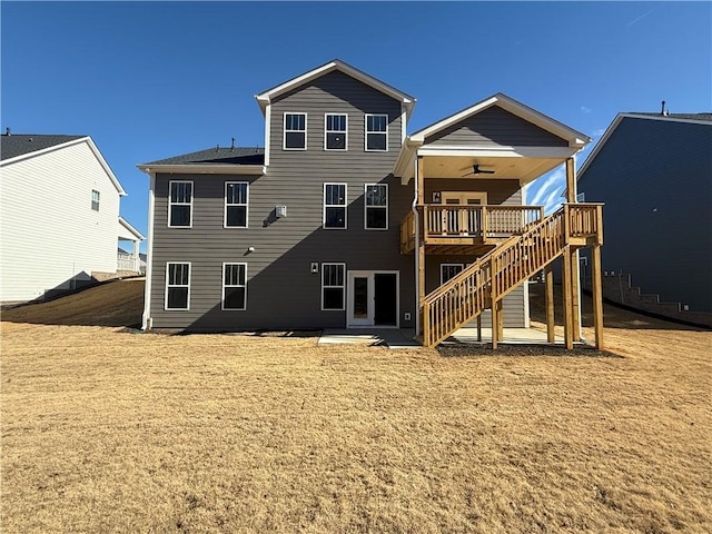 rear view of property featuring a wooden deck, ceiling fan, and a yard