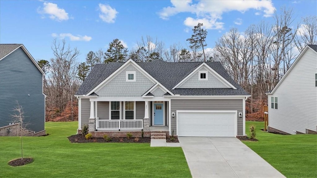 craftsman inspired home featuring a garage, a front yard, and covered porch