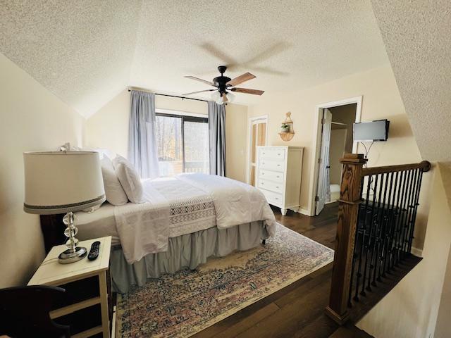 bedroom with vaulted ceiling, ceiling fan, a textured ceiling, and wood finished floors