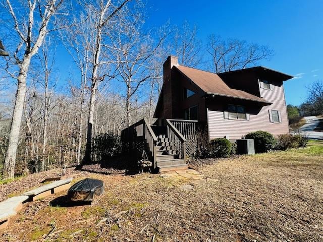 view of property exterior featuring stairs and a chimney