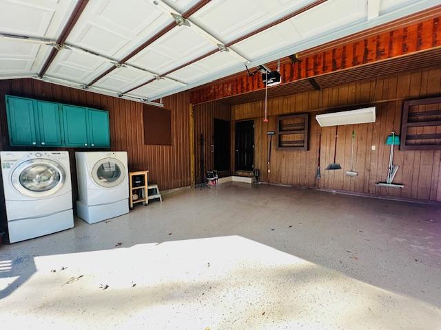 garage with washer and clothes dryer and a garage door opener