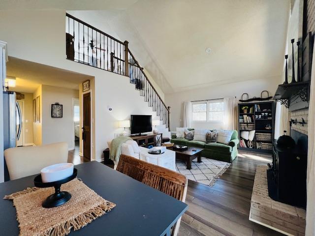 dining area with hardwood / wood-style floors and high vaulted ceiling