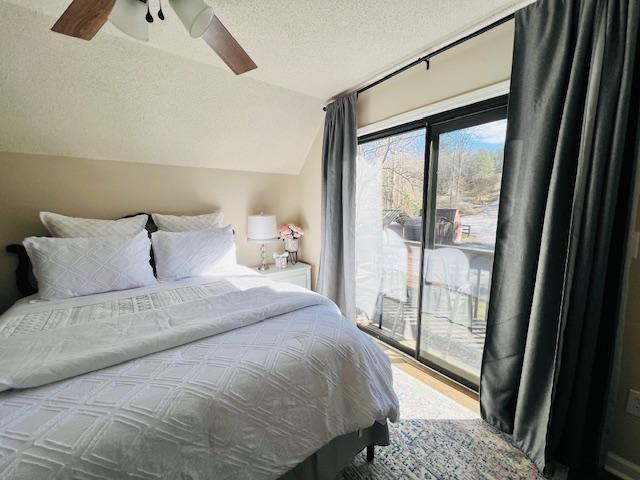 bedroom with lofted ceiling, a textured ceiling, access to outside, and ceiling fan