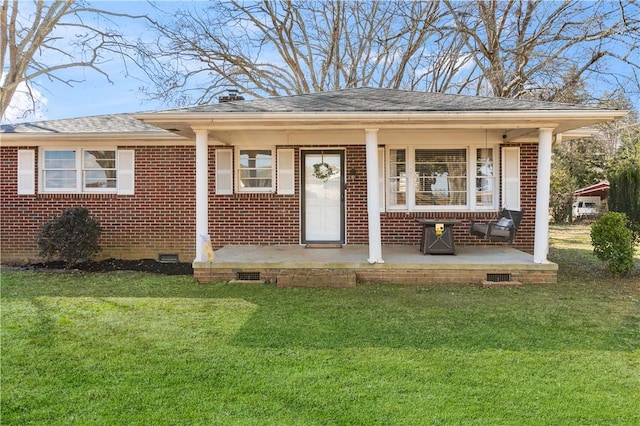 view of front of home with crawl space, brick siding, and a front yard