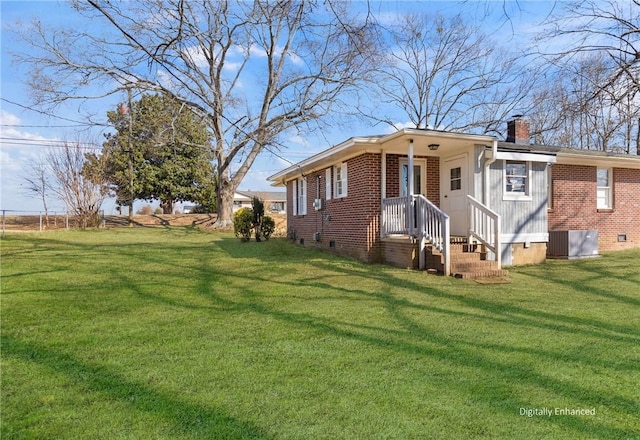 view of front of house featuring crawl space, brick siding, a chimney, and a front lawn