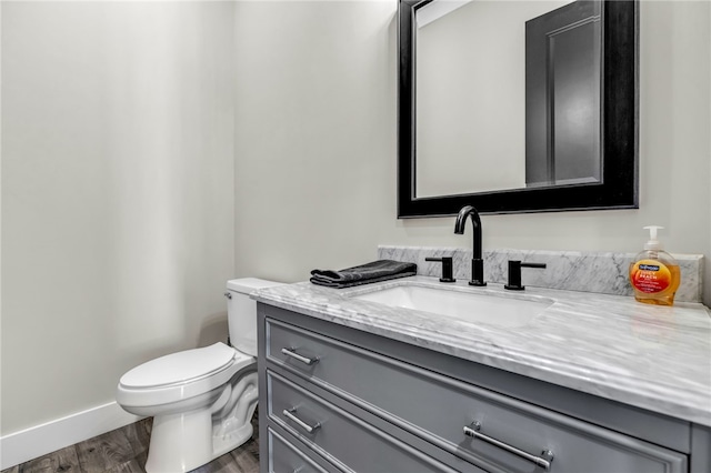 bathroom featuring hardwood / wood-style flooring, vanity, and toilet