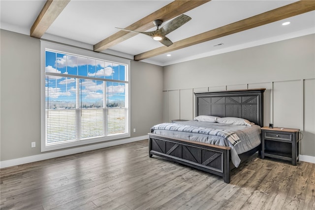 bedroom with hardwood / wood-style flooring, ceiling fan, and beam ceiling