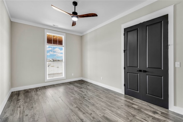 empty room with ornamental molding, light hardwood / wood-style floors, and ceiling fan