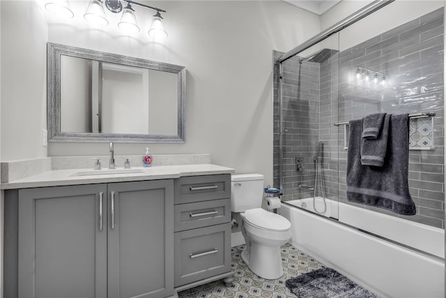 full bathroom with enclosed tub / shower combo, vanity, and toilet