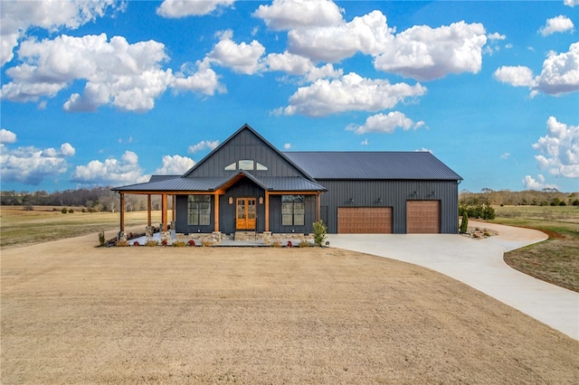 modern inspired farmhouse with a garage, a front yard, and covered porch