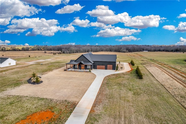 view of front of home featuring a garage, a rural view, and a front lawn