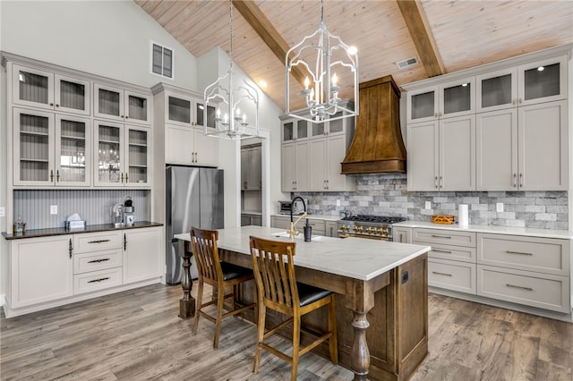 kitchen featuring beamed ceiling, appliances with stainless steel finishes, custom range hood, and wooden ceiling