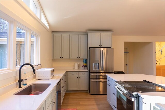 kitchen featuring sink, gray cabinets, stainless steel appliances, and light hardwood / wood-style floors