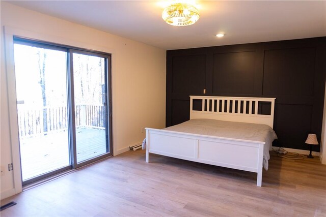 unfurnished bedroom featuring access to outside and light hardwood / wood-style flooring