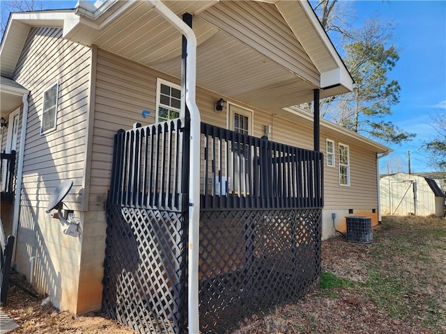 view of side of property with a storage shed and central AC